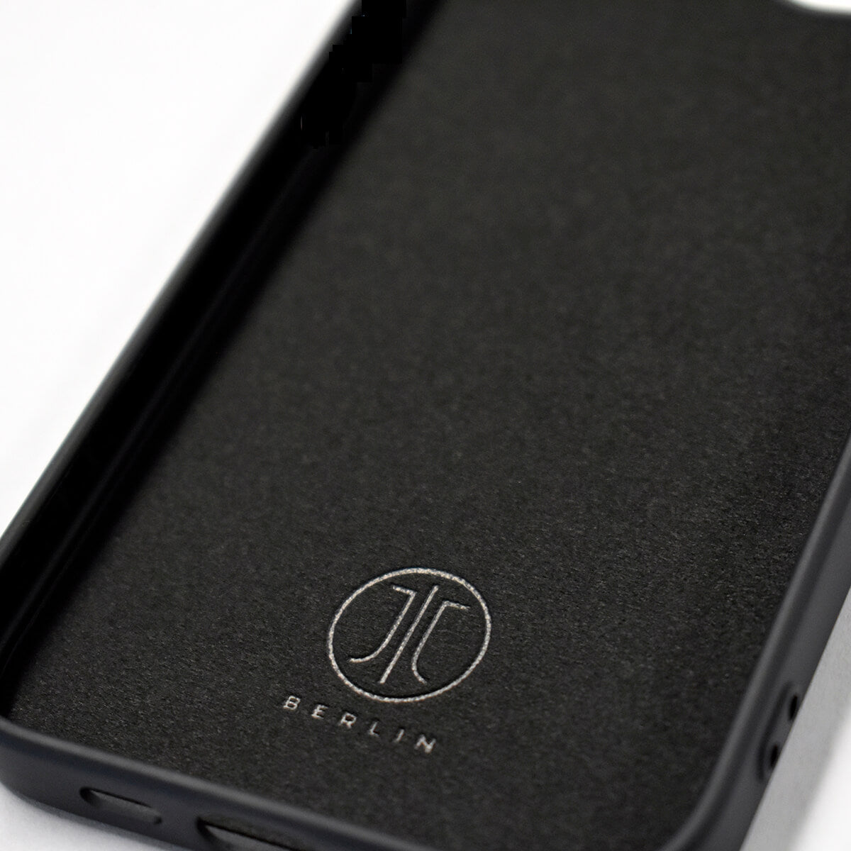 Das iPhone 16e – JT Pankow Soft MagSafe von JT Berlin ist eine schwarze TPU-Hülle mit eingeprägtem JL BERLIN-Logo auf der Innenseite, Anti-Schock-Technologie und auf weißem Hintergrund.