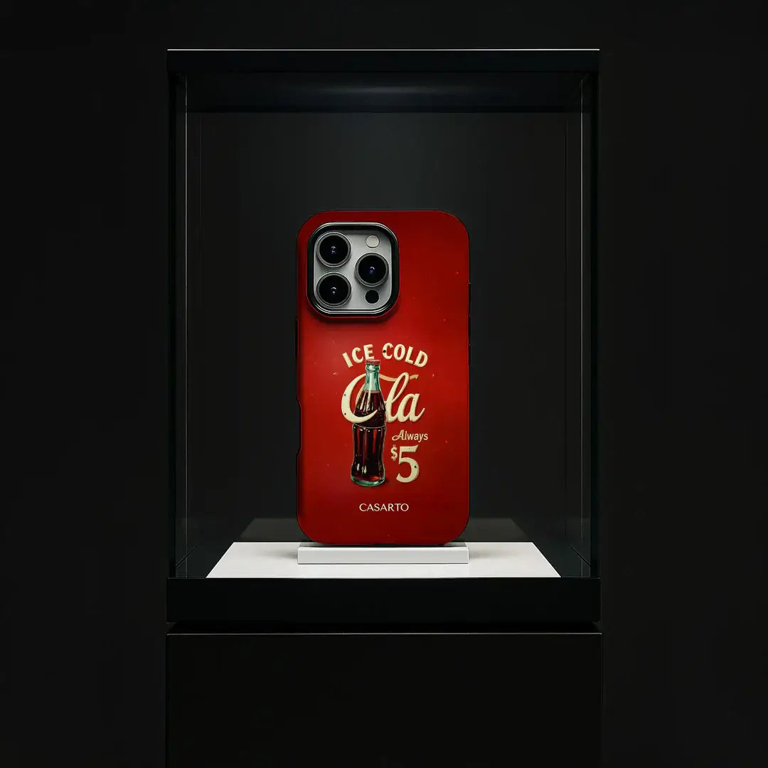 Eine rote Casarto Galaxy S25 Ultra Handyhülle "Taste the Feeling" Limited Art Edition, MagSafe-kompatibel, mit einem alten Coca-Cola-Design in einem Glasdisplay im Museumsstil.
