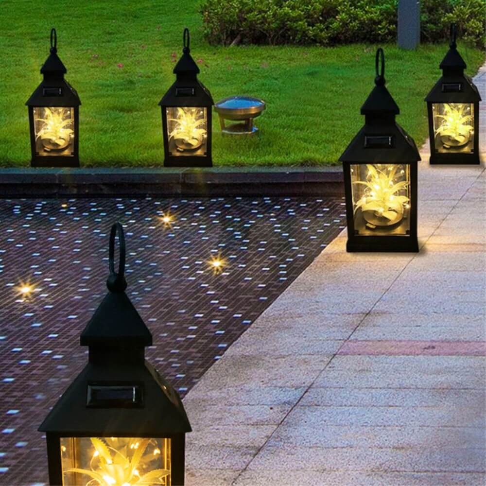 Fünf Cover-Discount Solar-Tischlampen-LED-Laternen säumen nachts einen Poolrand und werfen warmweißes Licht über die Fliesen und das Gras, alle angetrieben durch innovative Solartechnik.