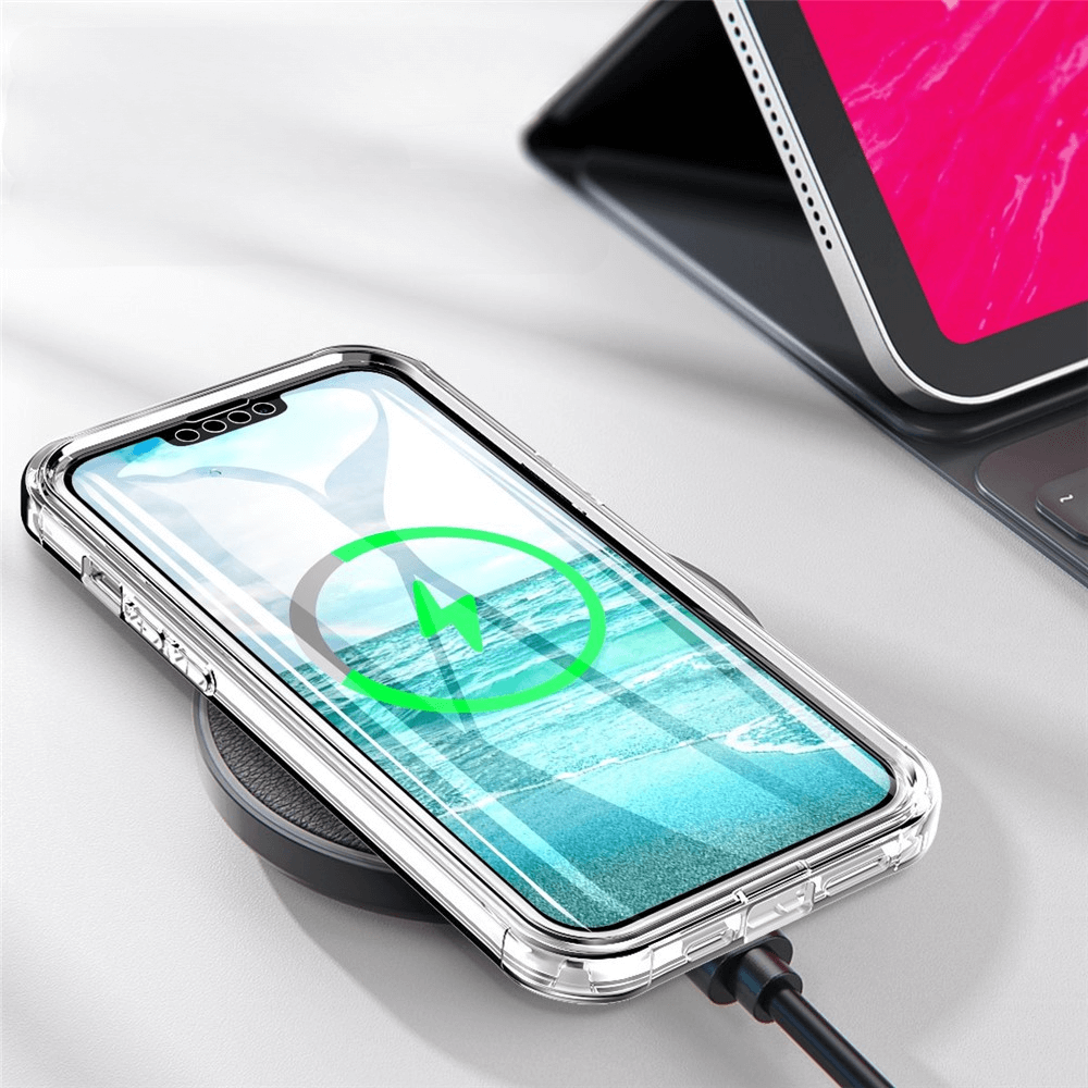 Ein iPhone 14 Pro in einer transparenten Cover-Discount Full Protection Schutzhülle lädt kabellos auf einem schwarzen Pad neben einem Tablet.