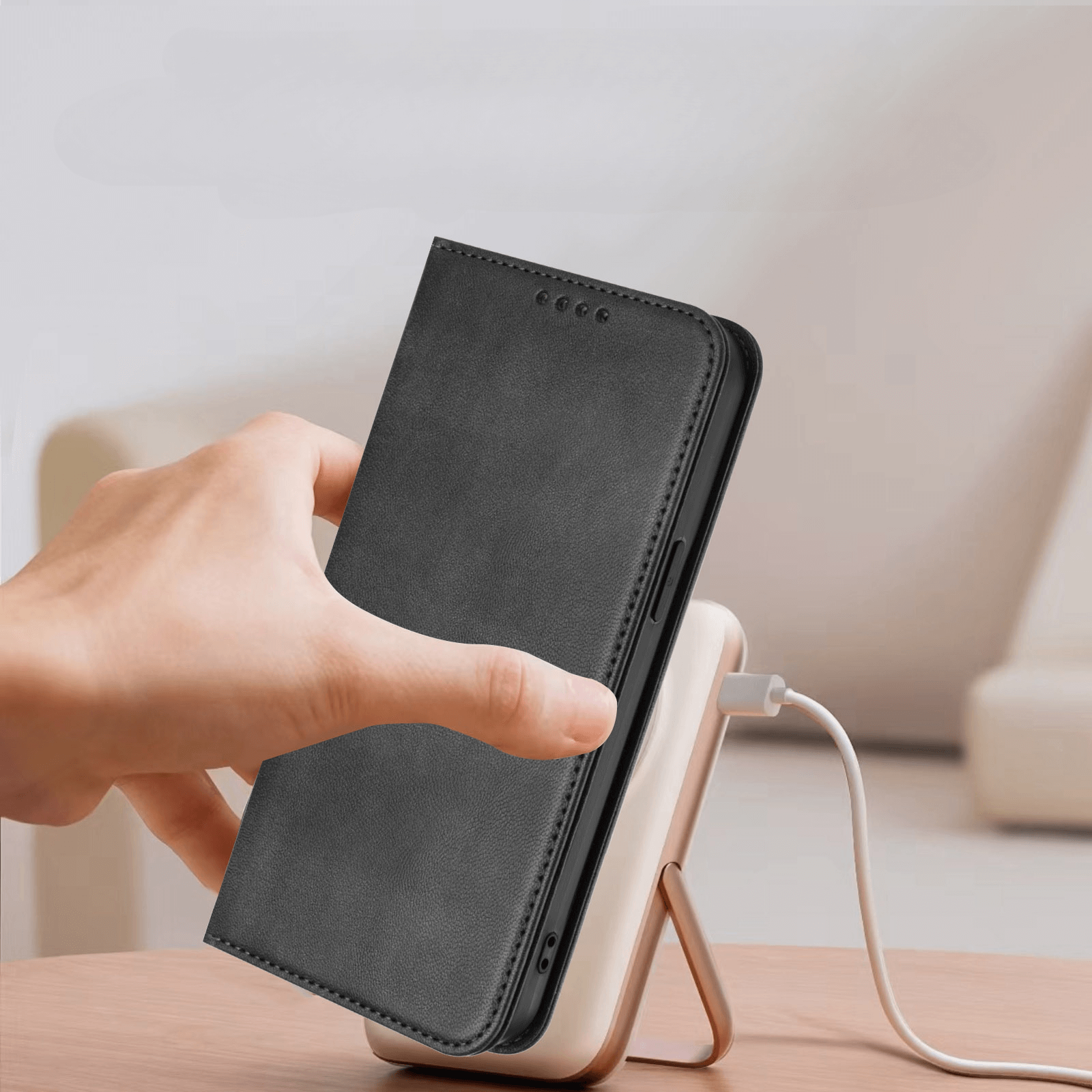 Eine Hand legt ein CMF Phone 2 Pro im Cover-Discount Flip Case mit RFID Blocker auf eine kabellose Ladestation auf einem Holztisch.