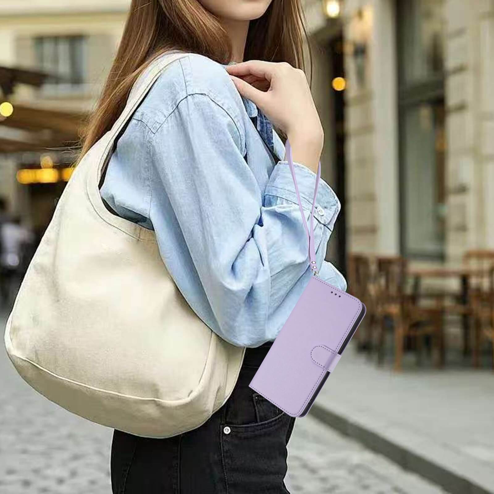 Eine Frau mit einer cremefarbenen Umhängetasche und einem lavendelfarbenen Cover-Discount iPhone 17 Air - Glänzendes Hüllen Etui mit Handschlaufe geht auf einer städtischen Straße.