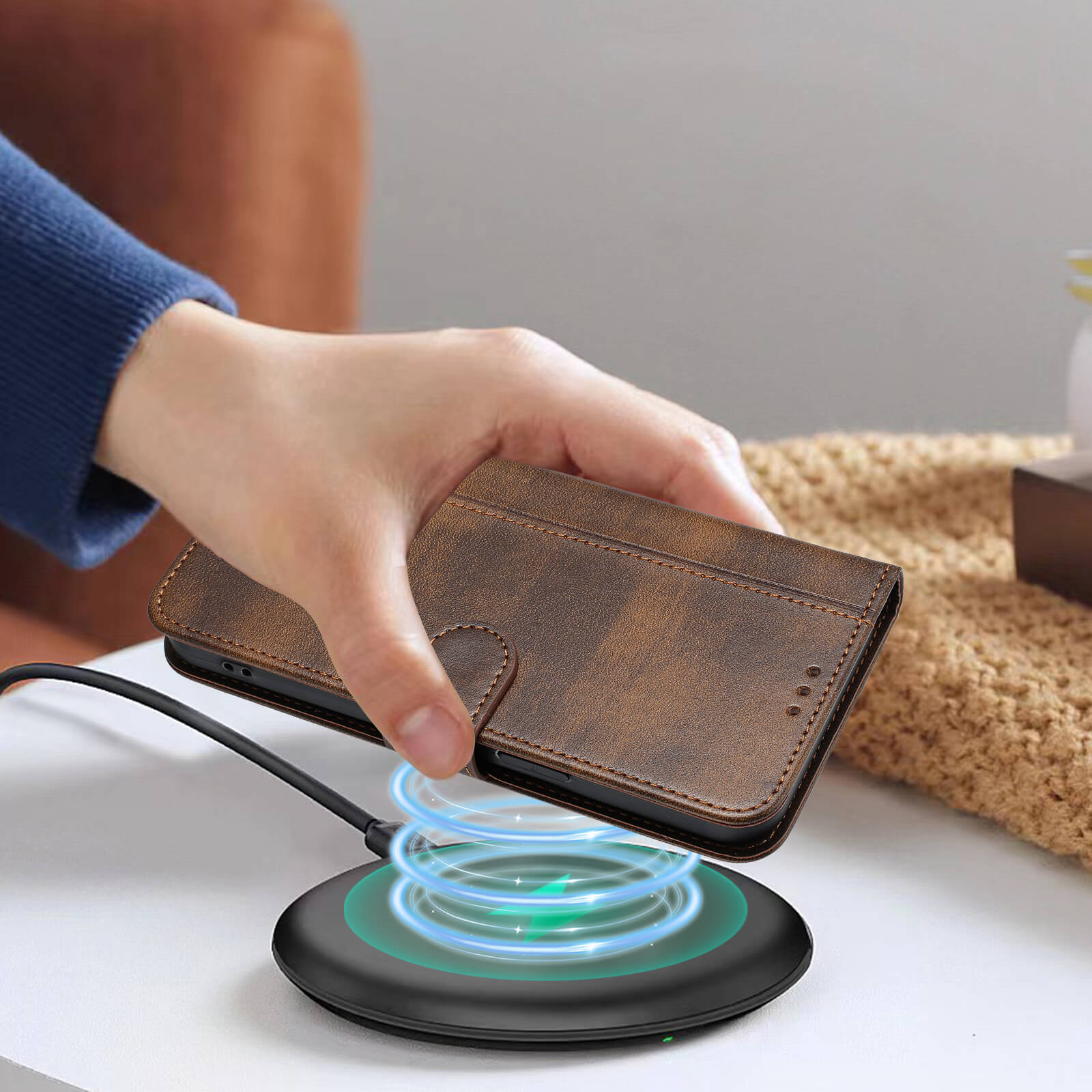 Eine Hand legt ein iPhone 17 Pro Max im Cover-Discount Wildleder Look Etui im Vintage Design auf ein mit blauem Licht leuchtendes Wireless Charging Pad.