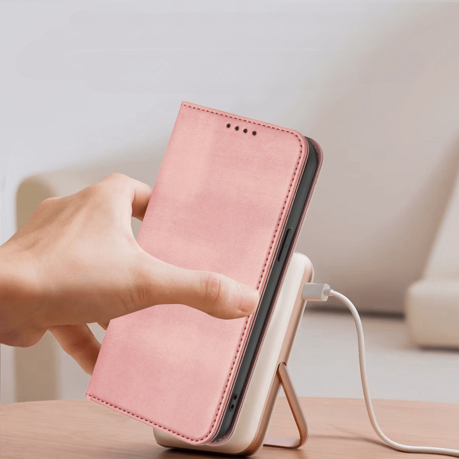 Eine Hand legt ein Telefon mit einem Cover-Discount iPhone 17 Pro Vintage Flip Case auf eine kabellose Ladestation auf einem Tisch.