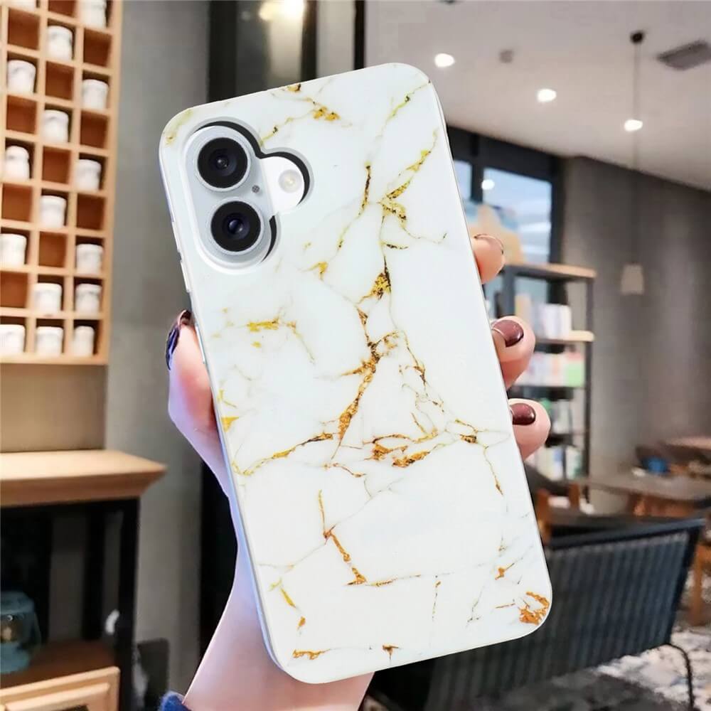 Eine Hand hält die Cover-Discount iPhone 17 - Silikon Hülle mit Marble Motiv, im schicken weiß-goldenen Design für stilvollen Schutz, in einem modernen, gemütlichen Raum.