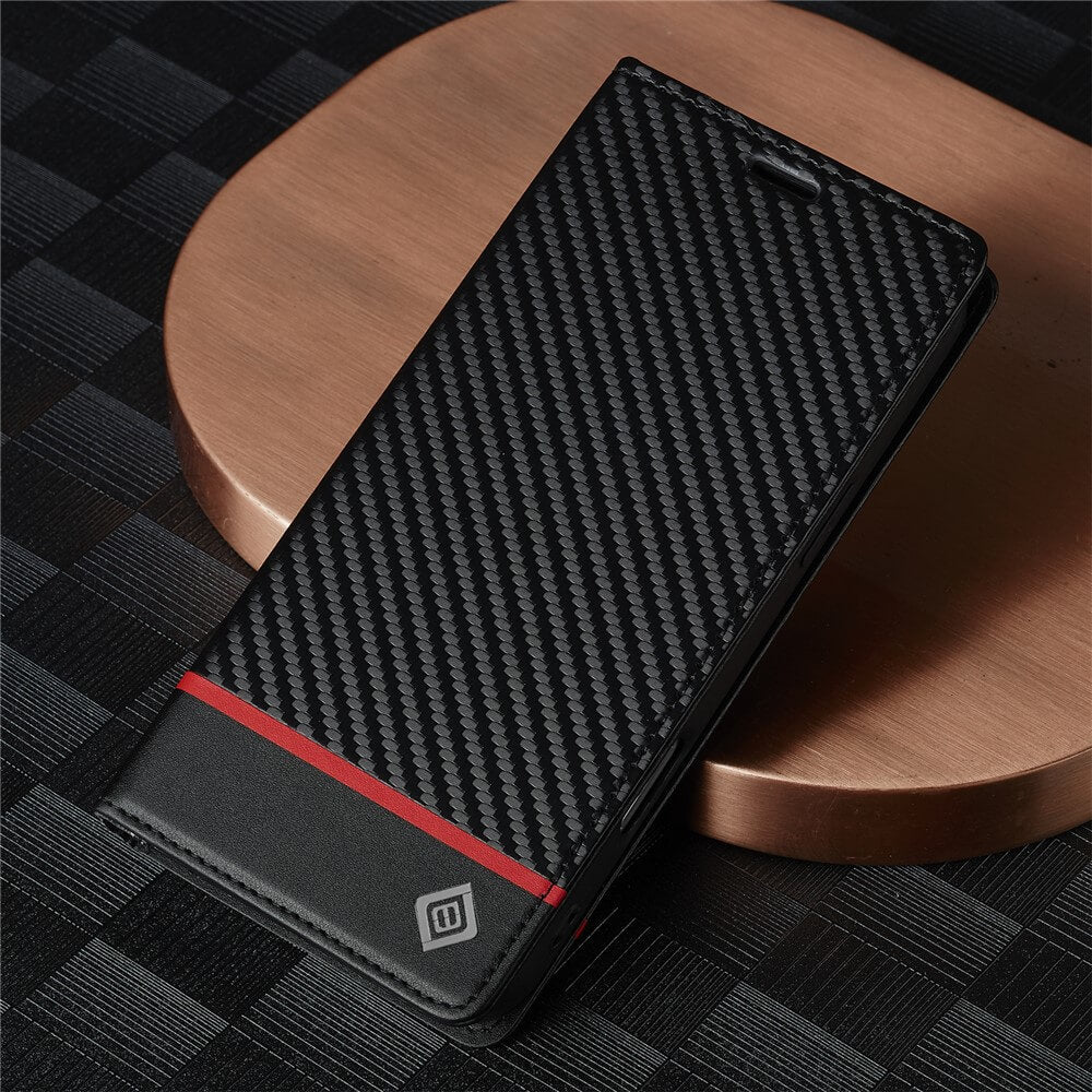 Elegante schwarze Handyhülle mit Carbonfaser-Struktur, rotem Streifen und silbernem Logo auf Metalluntergrund.