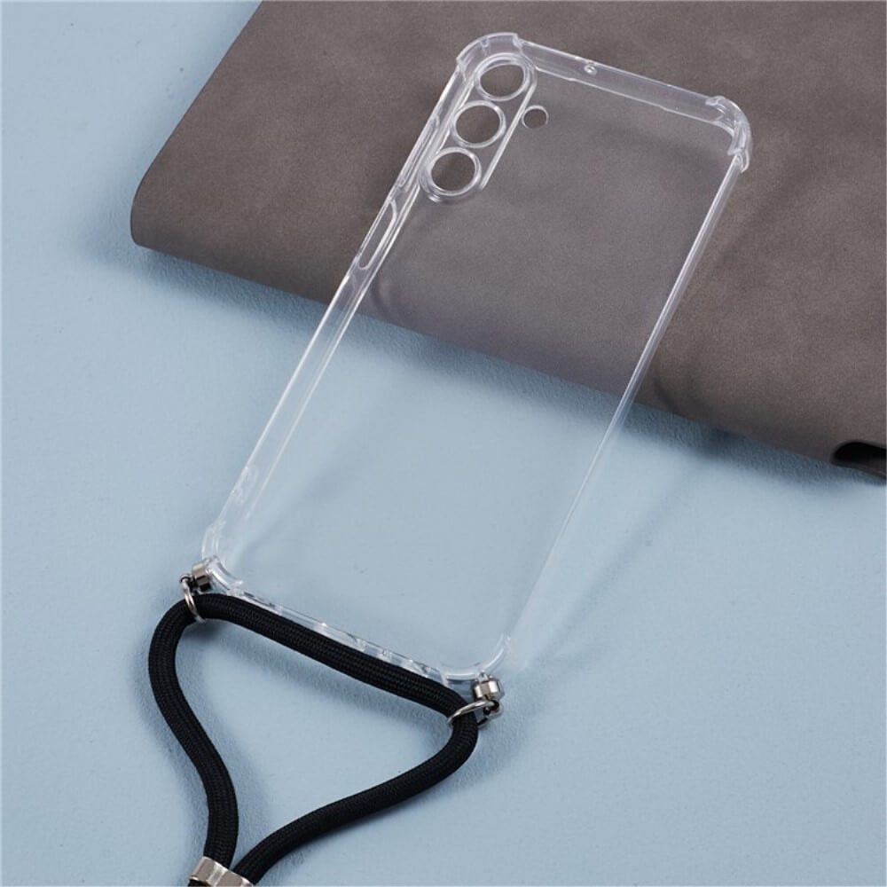 Die Cover-Discount Galaxy A55 - Hülle mit Umhängeband ist eine klare TPU-Hülle mit drei Kameraausschnitten und schwarzem Lanyard, auf einer grauen Oberfläche platziert.