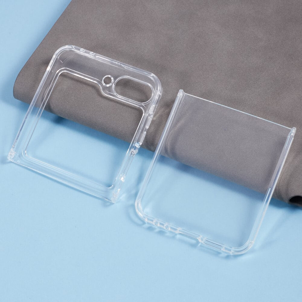 Two Cover-Discount Silikon Gummi Case transparent Hüllen für Galaxy Z Flip6 liegen auf einer hellblauen Fläche neben gefaltetem grauem Stoff.