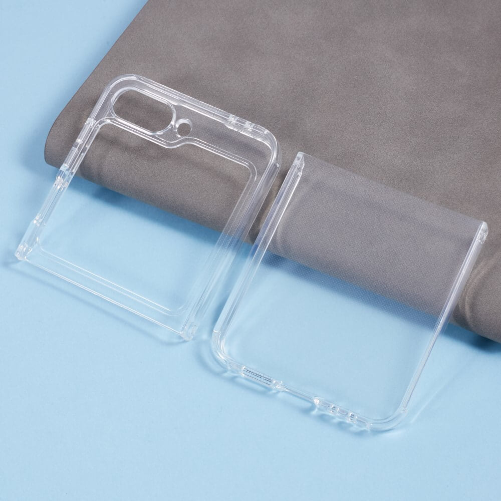 Zwei transparente Cover-Discount Galaxy Z Flip6 Silikon Gummi Cases liegen auf einer hellblauen Oberfläche vor einem grauen Stoffhintergrund.