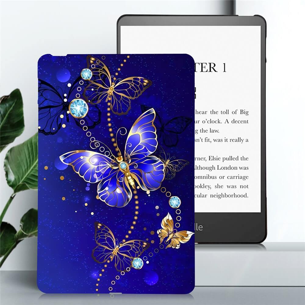 Die Cover-Discount Kindle Paperwhite 2024 Schutzhülle TPU mit Motiv in Blau mit goldenen Akzenten und Edelsteinen bietet flexiblen Rundumschutz; im Hintergrund ein E-Reader.