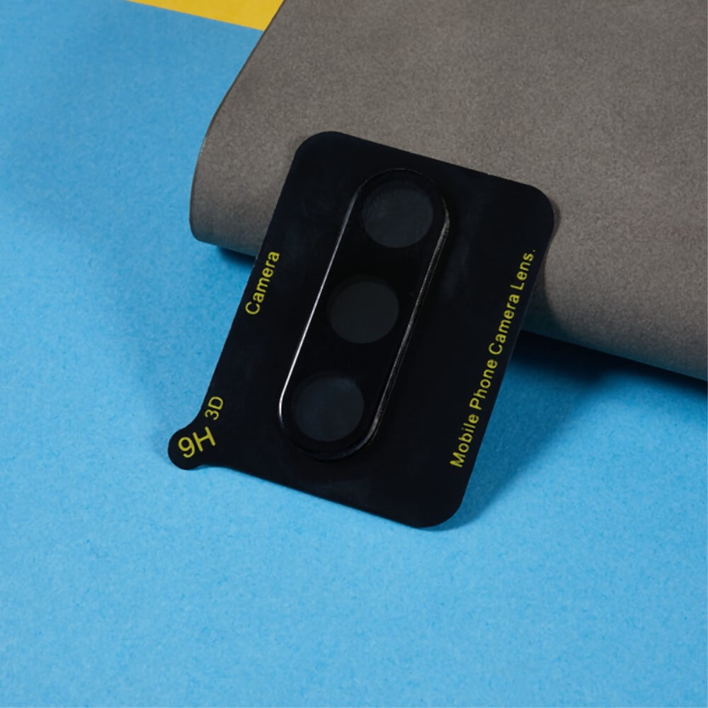 Ein schwarzer Panzerglas-Kameraschutz von Cover-Discount Galaxy S24 FE (2 Stück) liegt auf einem blau-grauen Hintergrund und bietet dauerhaften Kameraglasschutz für Galaxy S24 FE-Telefone.
