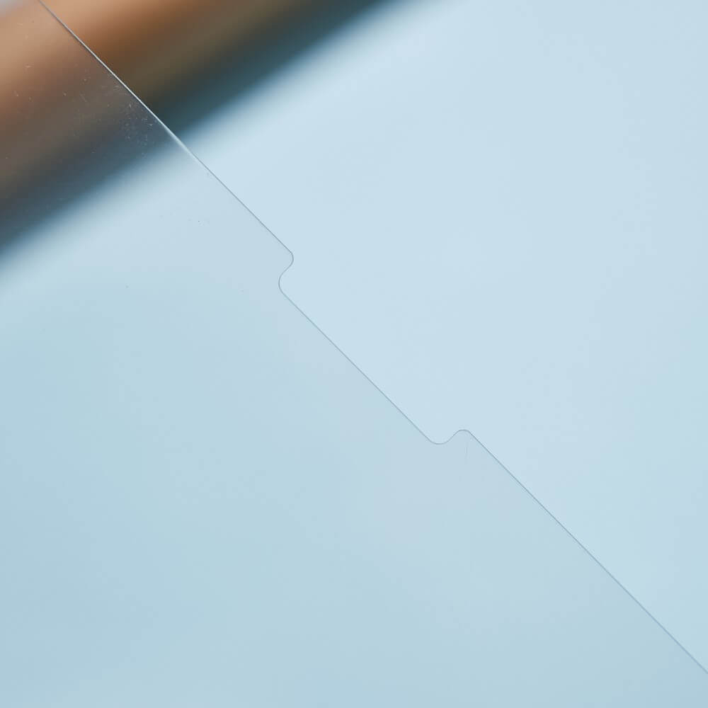Nahaufnahme eines klaren, dünnen Cover-Discount Panzerglas Schutzfolie Displays für das iPad Air 13 (M2/M3) mit einer kleinen Kerbe an einer Kante, auf einer hellen Oberfläche angebracht – perfekt für zuverlässigen Bildschirmschutz.