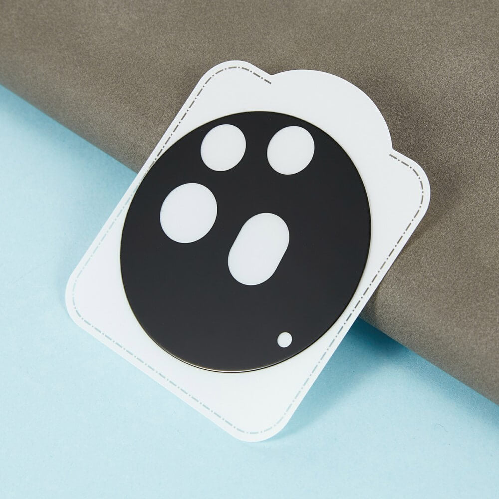 Das Cover-Discount Nothing Phone (3a) Pro – 2 Stk. Panzerglas Kamera bietet zuverlässigen Schutz für die Kameralinse mit einem schwarzen Schild mit vier Aussparungen, die auf einer weißen Karte auf einer blau-grauen Oberfläche angezeigt werden.