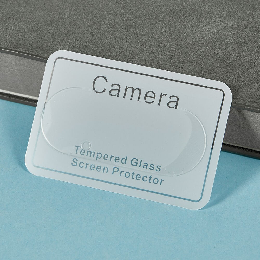 Transparenter Displayschutz aus gehärtetem Glas für Kameralinse, auf weißer Karte vor grauem Hintergrund