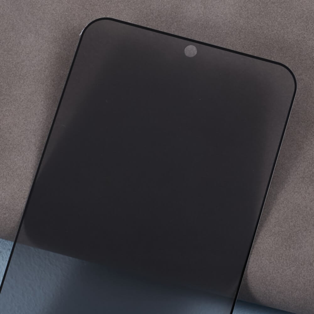 Eine Nahaufnahme des Panzerglas Display Privacy Anti-Spy-Displayschutzes von Cover-Discount Galaxy S25 Edge / S25+ / S24+ Plus mit Kameraausschnitt auf einer grauen Oberfläche, entwickelt für optimalen Datenschutz.