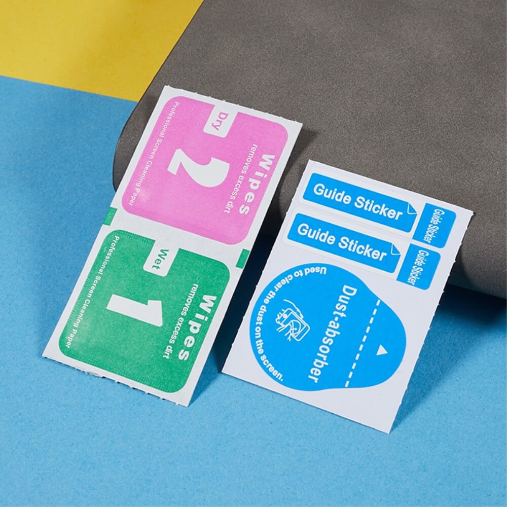 Reinigungstücher für Telefonbildschirme, blaue Anleitungsaufkleber und ein graues Werkzeug auf lebendigem Hintergrund – ideal zum Vorbereiten Ihres Geräts vor dem Anbringen des Panzerglas Display Privacy Anti-Spy-Schutzes von Cover-Discount Galaxy S25 Edge / S25+ / S24+ Plus.