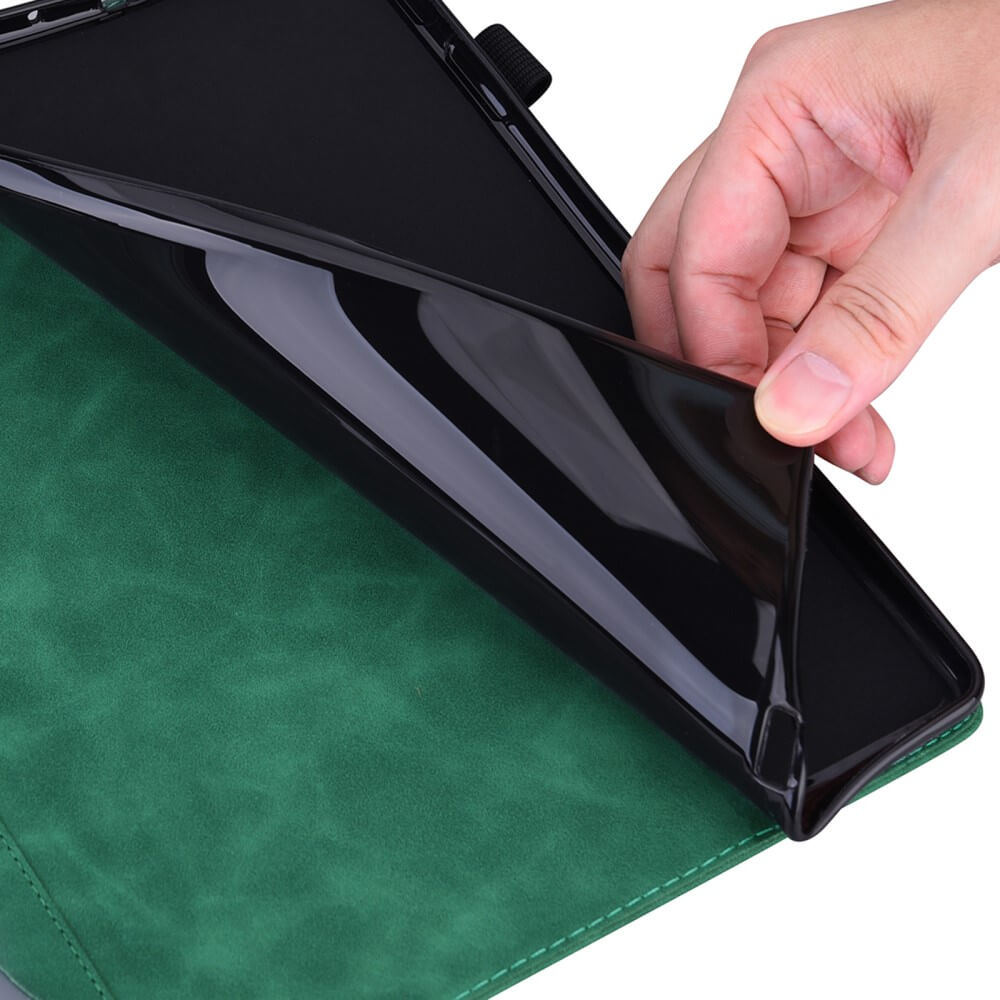 Eine Hand hebt ein flexibles schwarzes Cover-Discount Etui mit Kartenfächern für Kindle Paperwhite 2024 auf einer grünen Tablet-Hülle.