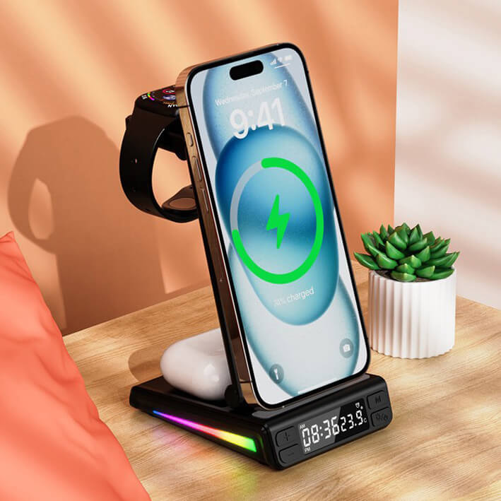 Die Multifunktionale magnetische kabellose Ladestation von Cover-Discount.ch für Smartphone, Earbuds und Smartwatch mit LED-Uhranzeige steht neben einer kleinen Pflanze auf dem Schreibtisch.