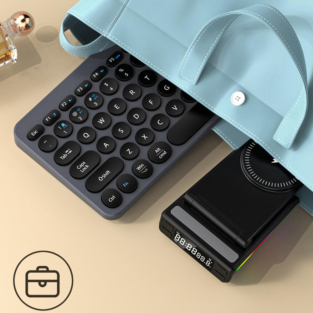 Eine hellblaue Tasche, eine runde Tastatur und eine Cover-Discount.ch Multifunktionale magnetische kabellose Ladestation für Smartphone/Earbuds/Smartwatch mit LED-Uhranzeige liegen teilweise sichtbar auf dem Tisch.