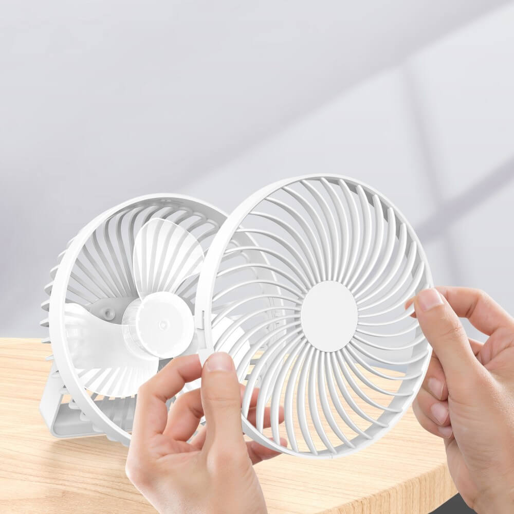 Entfernen Sie mit den Händen die vordere Abdeckung eines weißen Cover-Discount Mini Ventilator Camping tragbar, eines kleinen praktischen USB-Tischventilators, der auf einer hellen Holzoberfläche platziert ist.