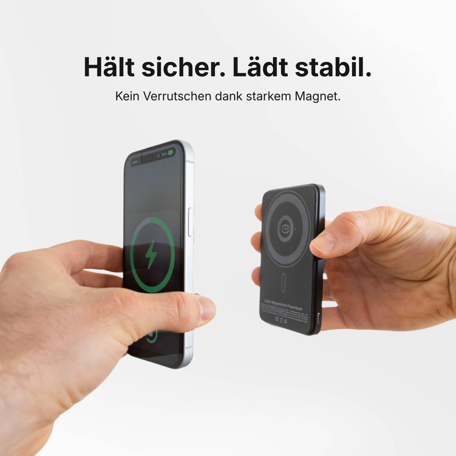 Das SEEKR SWISS SEEKR Power Mag - Schwarz 5000 mAh wird mit zwei Händen an einem Smartphone befestigt und aktiviert das Ladesymbol für kabelloses Schnellladen mit seinem ultradünnen Design.