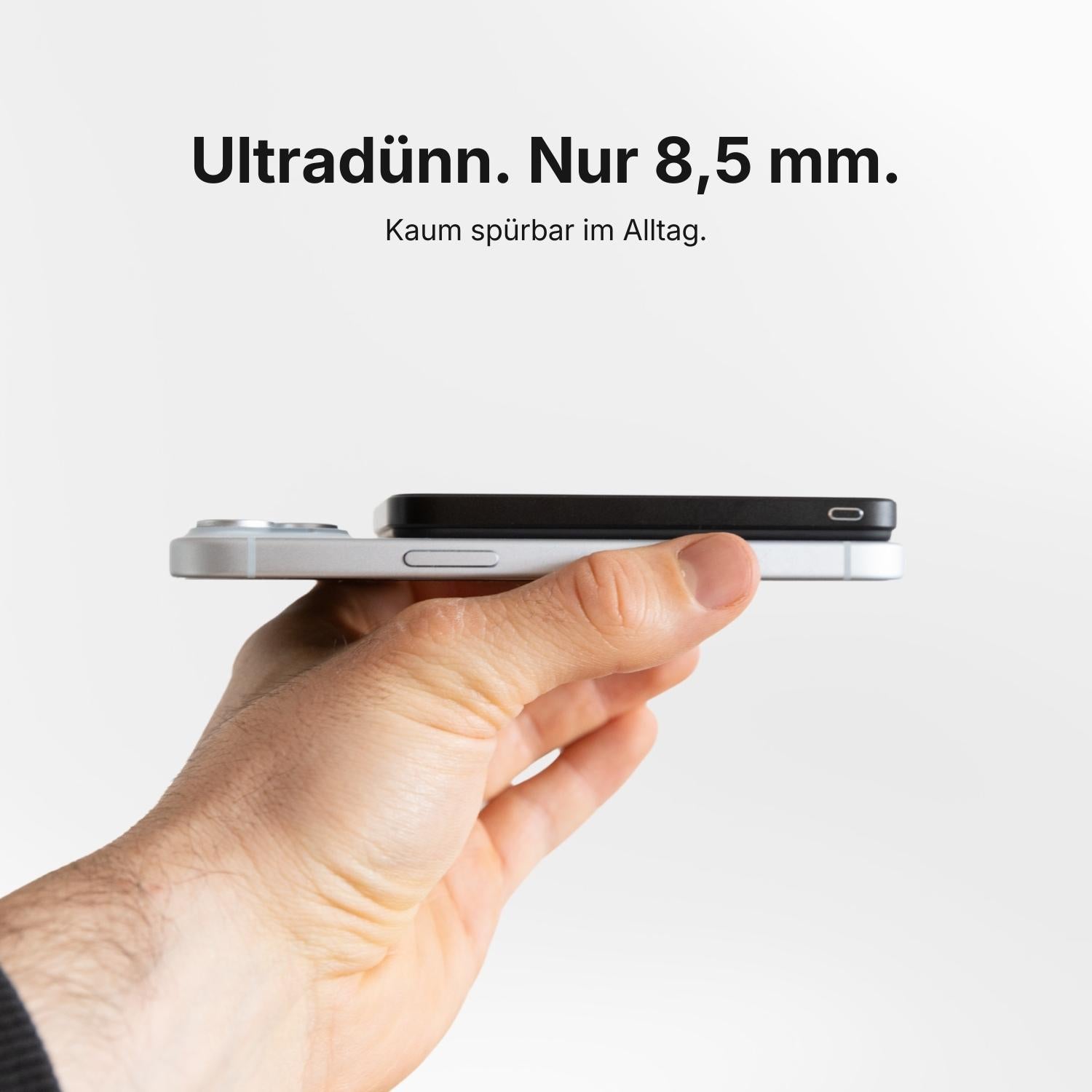 Eine Hand hält zwei SEEKR SWISS SEEKR Power Mag - Schwarz 5000 mAh Geräte gestapelt, mit deutschem Text, der ihr ultradünnes 8,5 mm Design betont.