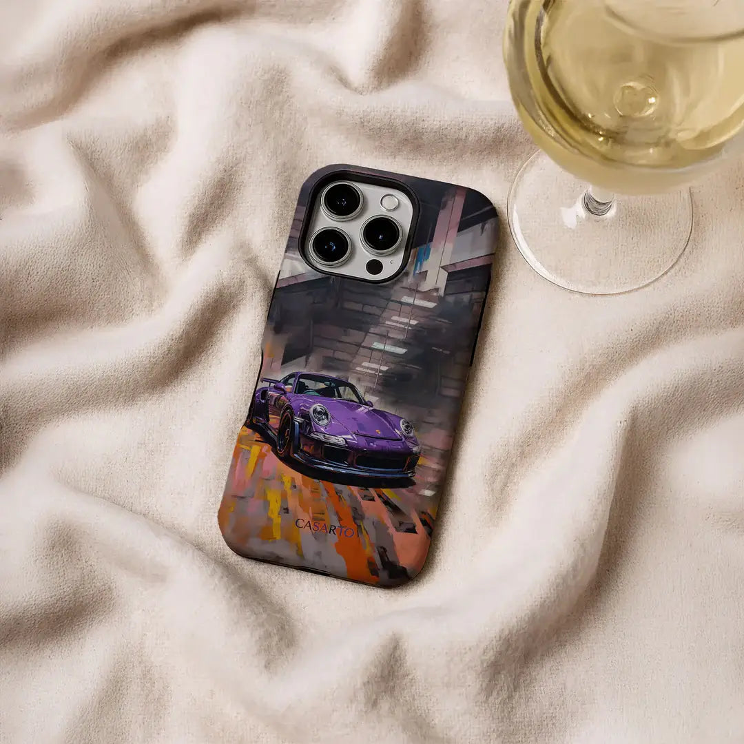 Ein iPhone 17 Pro mit der Casarto Handyhülle Pure Power in limitierter Auflage von Cover-Discount mit lila Sportwagenmotiv ruht auf beigem Stoff neben einem Glas Weißwein.