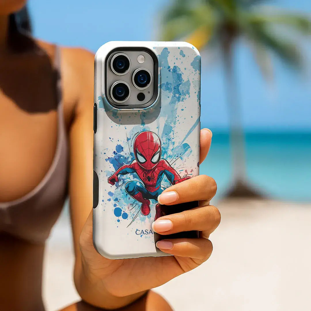 Eine Frau hält eine Casarto Galaxy S25 Ultra Spider-Man Handyhülle auf ihrem Handy an einem sonnigen Strand mit Palmen.