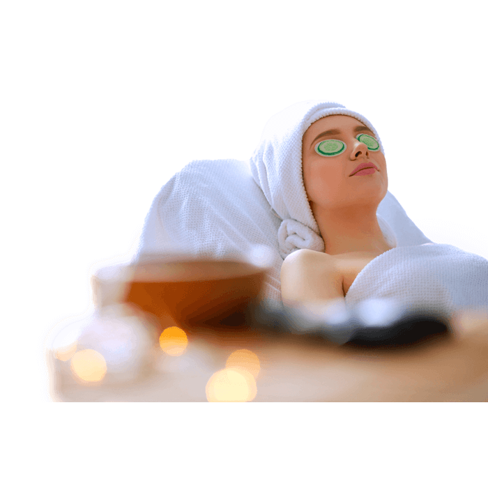 Eine Frau entspannt in einem Spa mit einem Handtuch auf dem Kopf, während Out of the blue Spa Augenpads Heiss & Kalt im Gurkendesign ihre Augen kühlen.