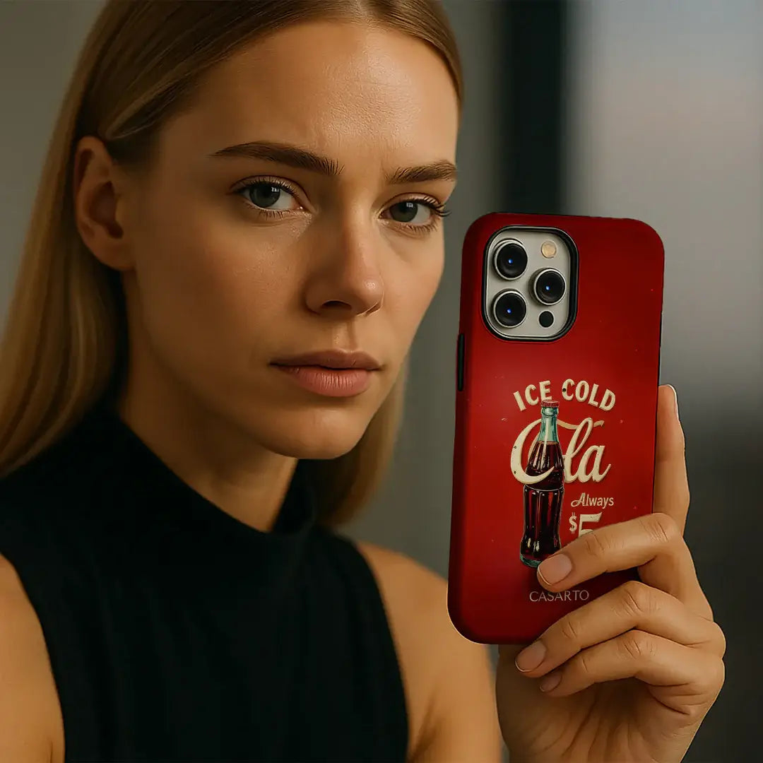 Eine Frau hält ein Telefon mit der Casarto Galaxy S25 Ultra Handyhülle "Taste the Feeling", die eine alte Coca-Cola Flasche und ein Logo zeigt. Diese Limited Art Edition ist MagSafe kompatibel und für einfaches Aufladen konzipiert.