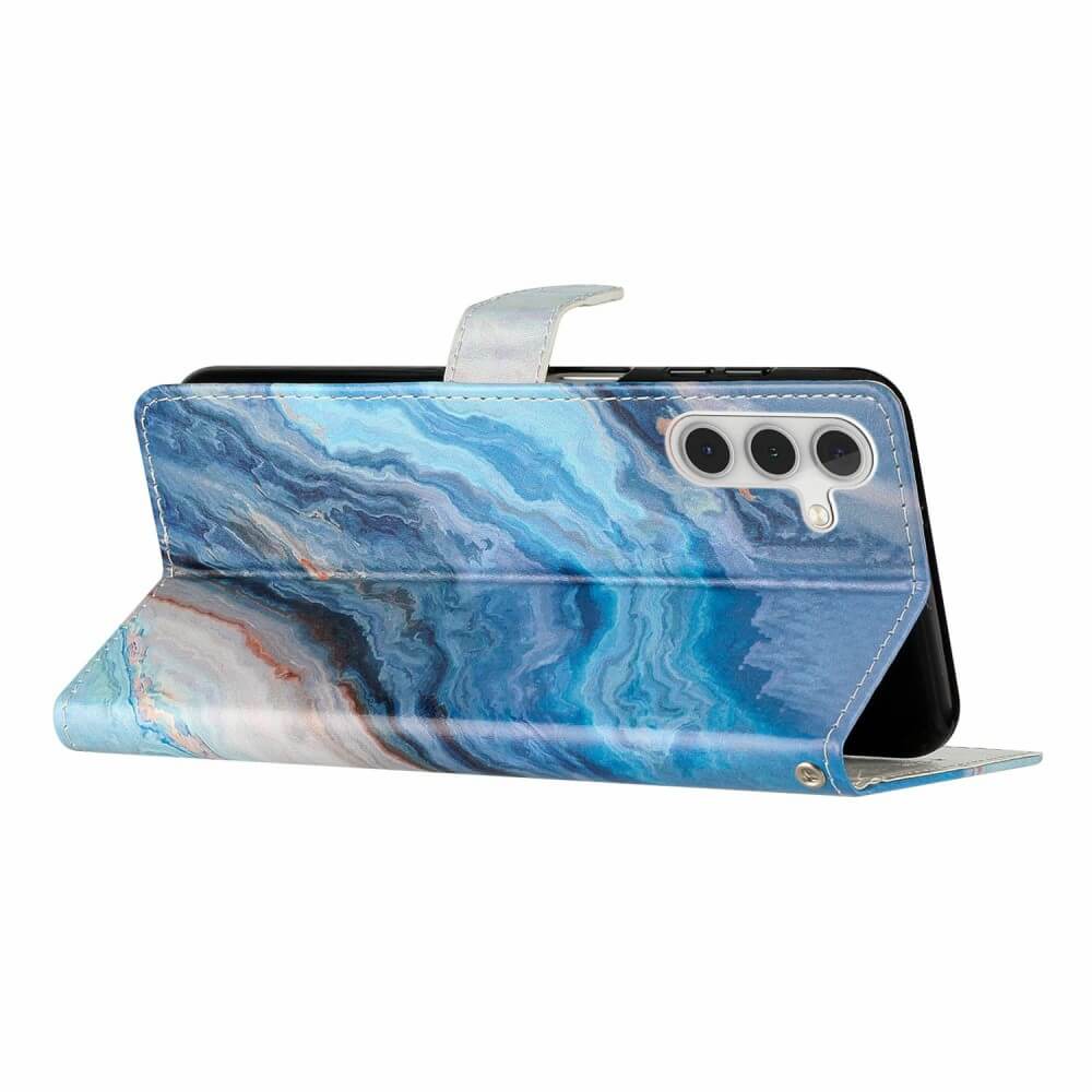 Das Galaxy A36 5G steckt in der Cover-Discount Tasche Hülle mit Motiv im blauen Marmor-Look; Sie bietet Rundum-Schutz, Standfunktion und passt für Modelle mit drei Kameraobjektiven.