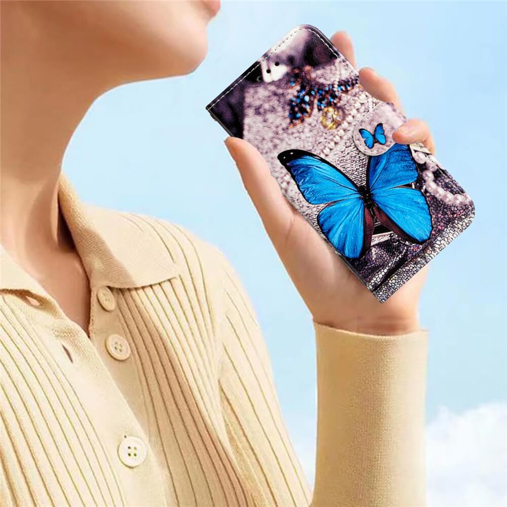 Eine Frau hält ihr Telefon mit einem blauen Schmetterling Cover-Discount iPhone 17 Air - Tasche Hülle mit Motiv gegen einen hellen, klaren Himmel.