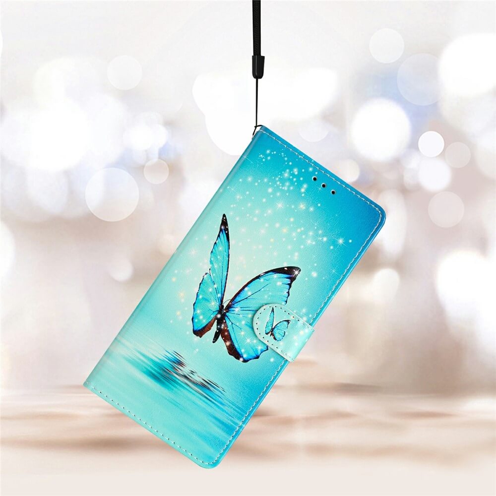 Die Cover-Discount iPhone 17 Air - Tasche Hülle mit Motiv zeigt einen Schmetterling und Glitzer, hängt an einem schwarzen Band vor unscharfem Hintergrund - die stilvolle Handyhülle für dein Smartphone.