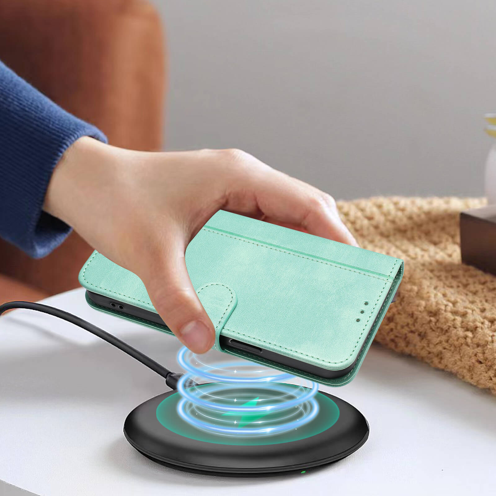 Eine Hand legt ein mintgrünes Cover-Discount iPhone 17 - Retro Look Etui im Vintage Design auf ein rundes kabelloses Ladepad, das mit blauer Energie leuchtet.