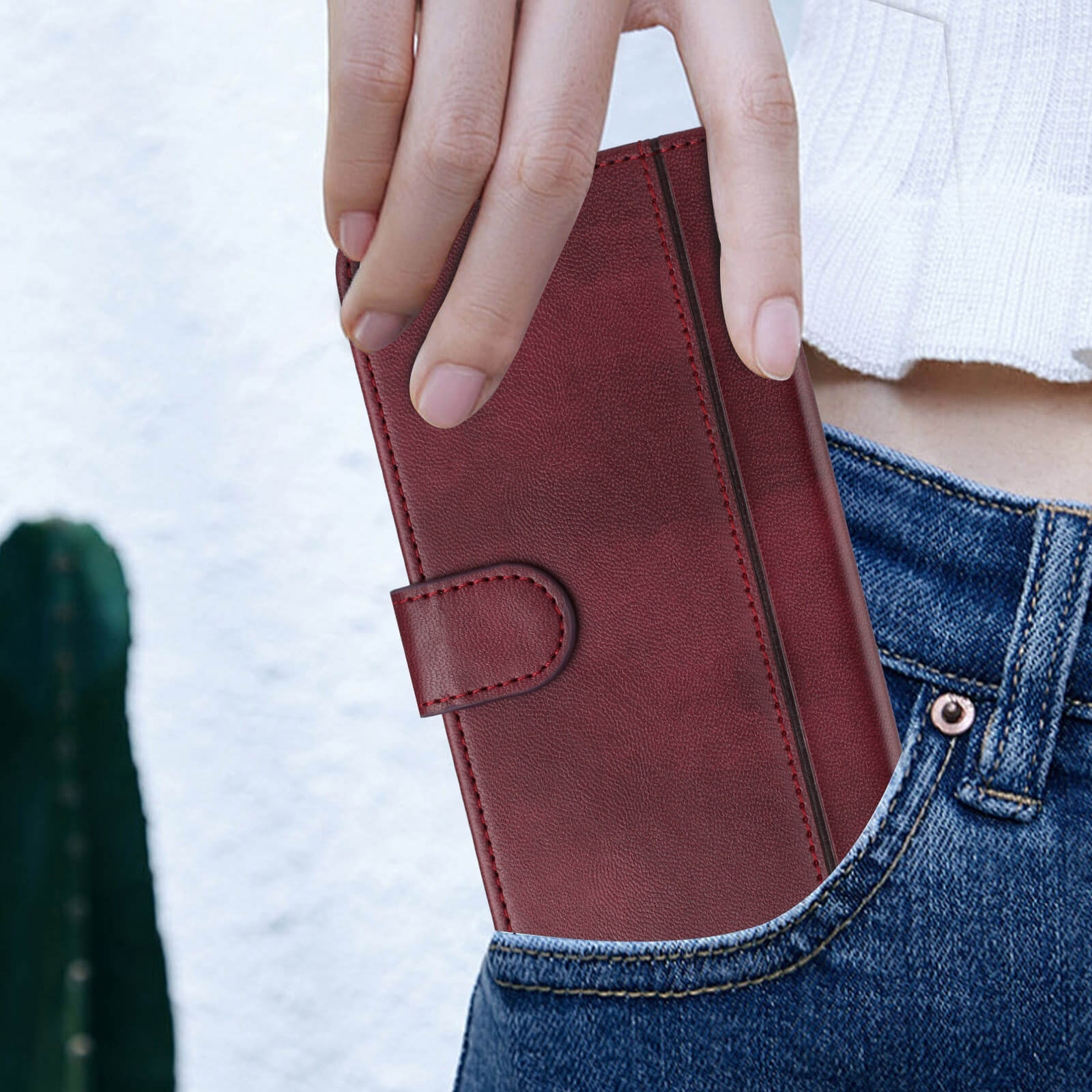 Eine Hand steckt das Cover-Discount iPhone 17 - Retro Look Etui im Vintage Design in die Vordertasche einer Blue Jeans.