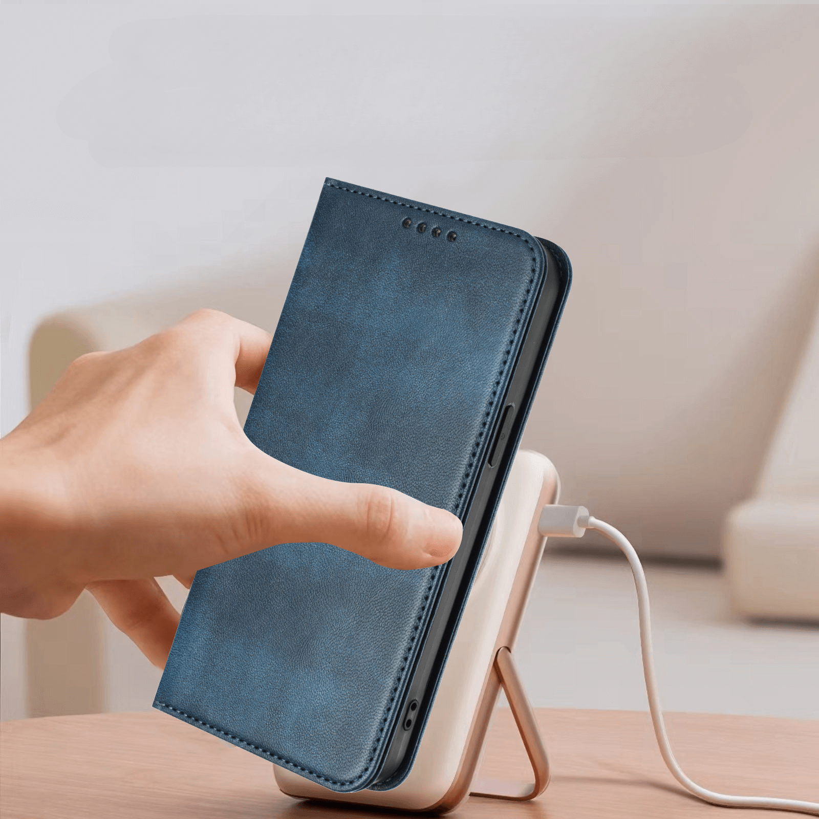 Eine Hand legt ein Telefon mit dem Cover-Discount iPhone 17 - Vintage Flip Case auf eine kabellose Ladestation auf einem Tisch.