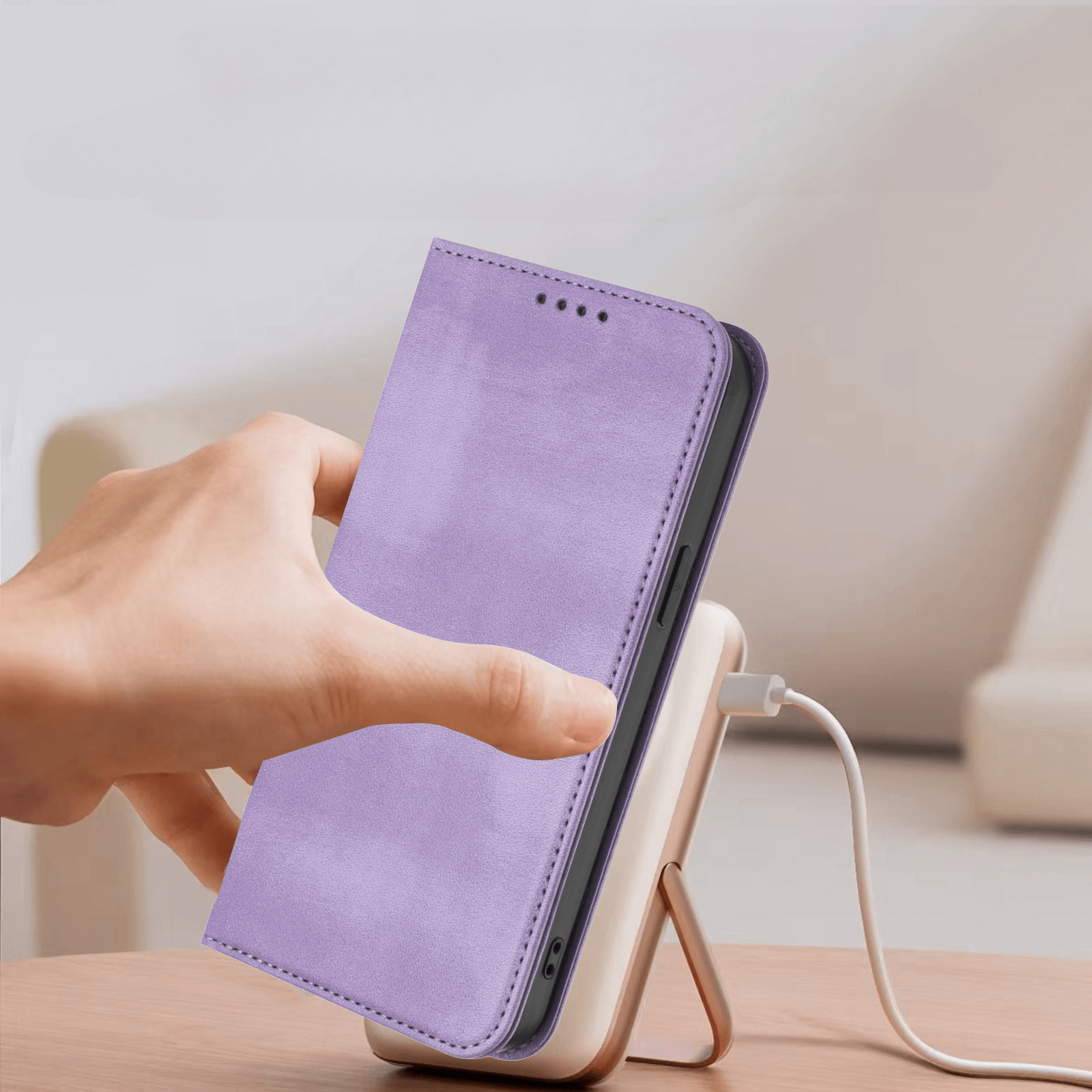 Eine Hand legt ein Smartphone mit einem Cover-Discount iPhone 17 Vintage Flip Case in Lavendel auf eine kabellose Ladestation.