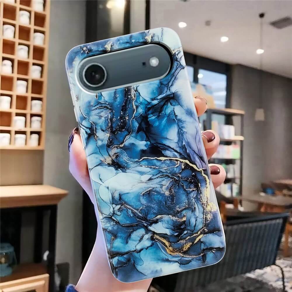 Eine Hand hält die Cover-Discount iPhone 17 Air - Silikon Hülle mit Marble Motiv, die ein auffälliges blaues Marmor-Design aufweist, in einem modernen, gut beleuchteten Raum.