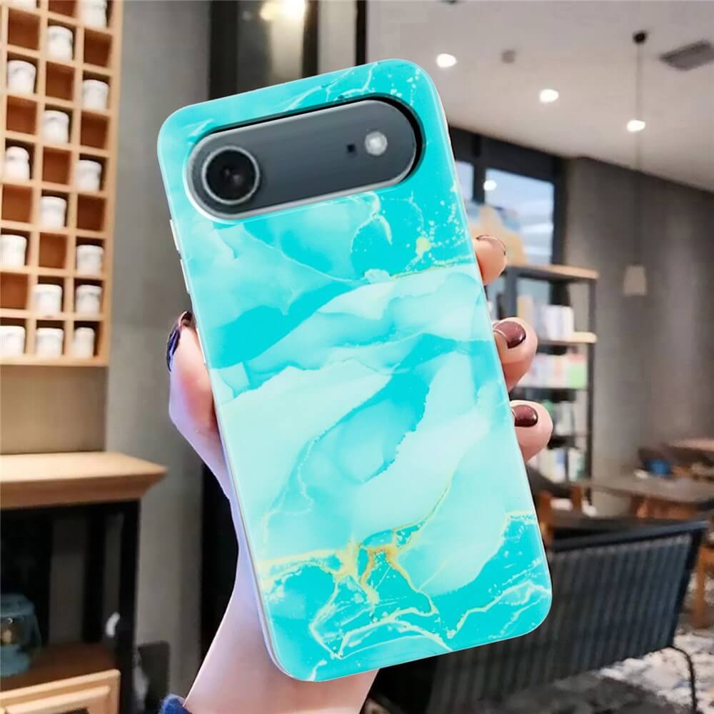 In einem hellen, modernen Café hält eine Hand die Cover-Discount iPhone 17 Air Silikon Hülle mit Marble Motiv in auffälligem Blau.