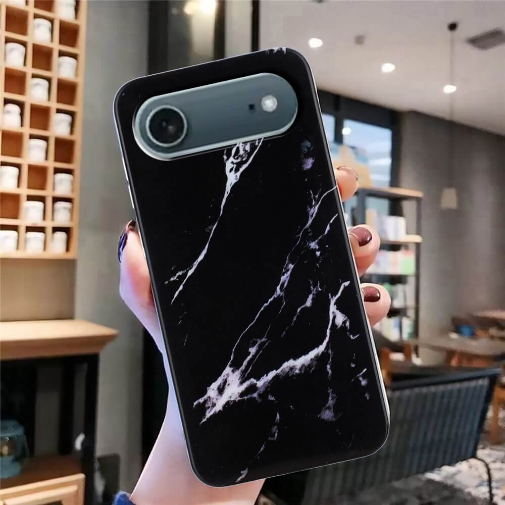 Eine Hand hält die Cover-Discount iPhone 17 Air - Silikon Hülle mit Marble Motiv in einem modernen, gemütlichen Café.