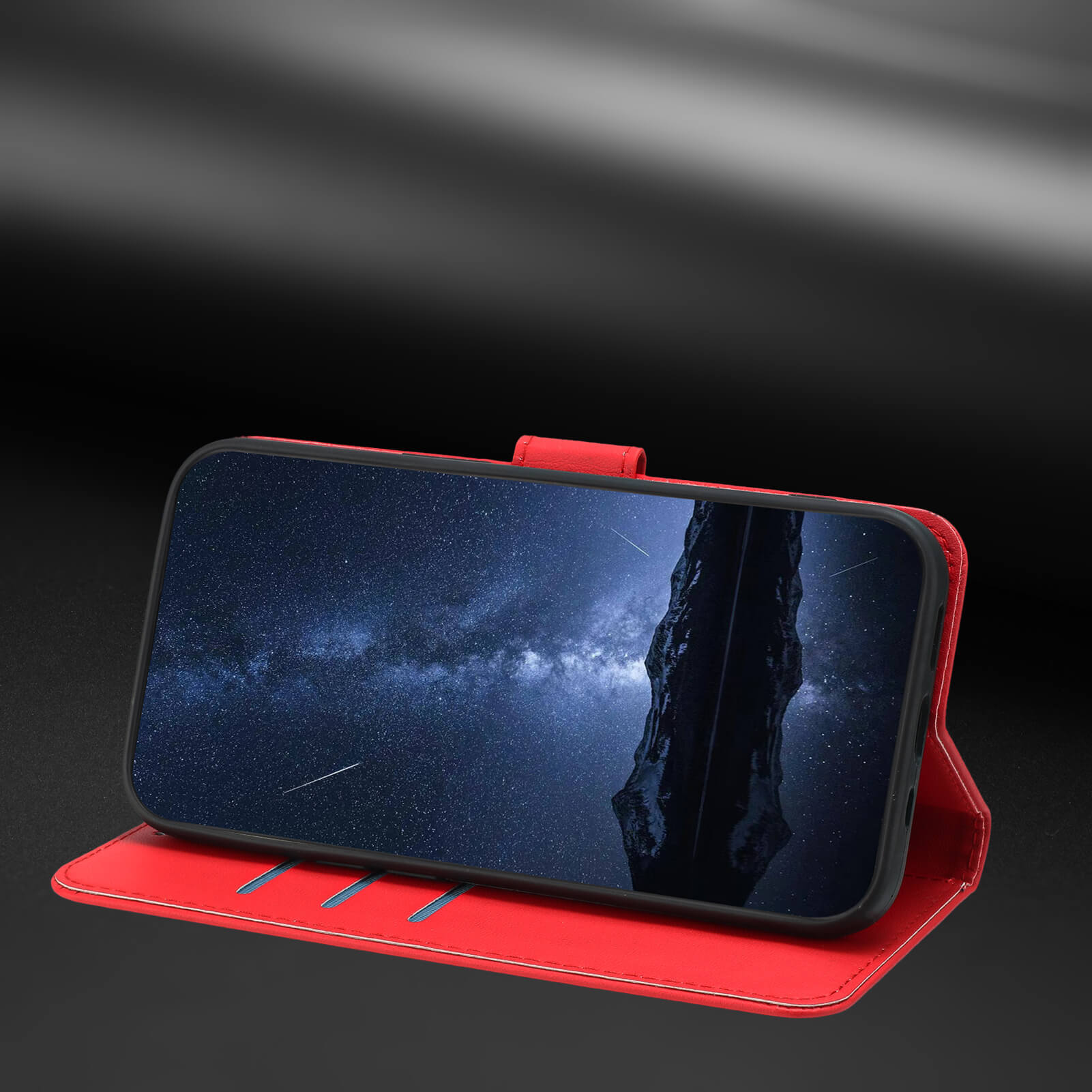 Ein rotes iPhone 17 - Elegante Ledertasche von Cover-Discount steht aufrecht und zeigt einen sternenklaren Nachthimmel mit einer dunklen Silhouette auf dem Bildschirm.