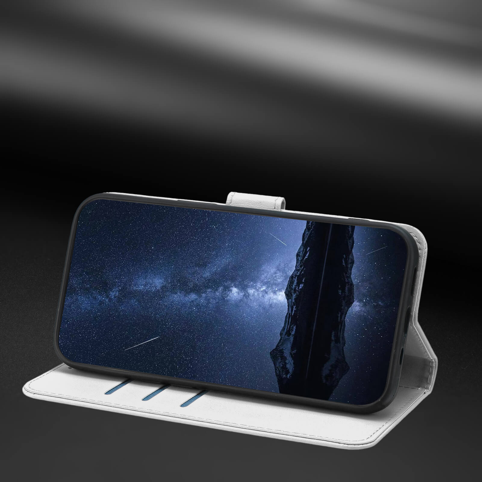 Ein Smartphone in der Cover-Discount iPhone 17 Elegante Ledertasche steht aufrecht und zeigt einen sternenklaren Nachthimmel mit einer dunklen Felsformation.