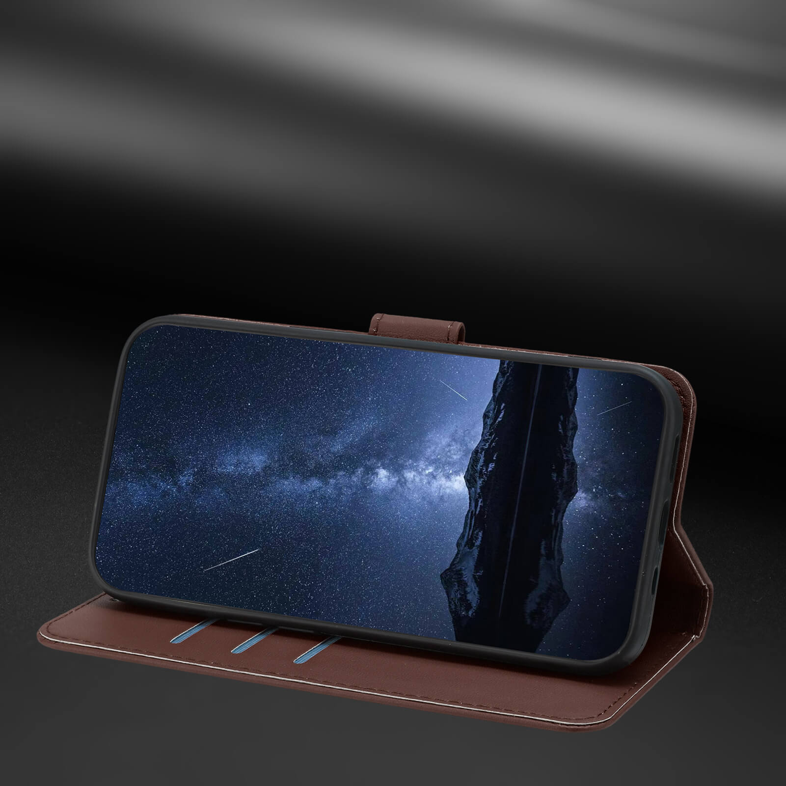 Ein iPhone 17 in der Eleganten Ledertasche von Cover-Discount steht mit Sternenhimmel auf dunkler Oberfläche; die braune Hülle bietet eine praktische Standfunktion.