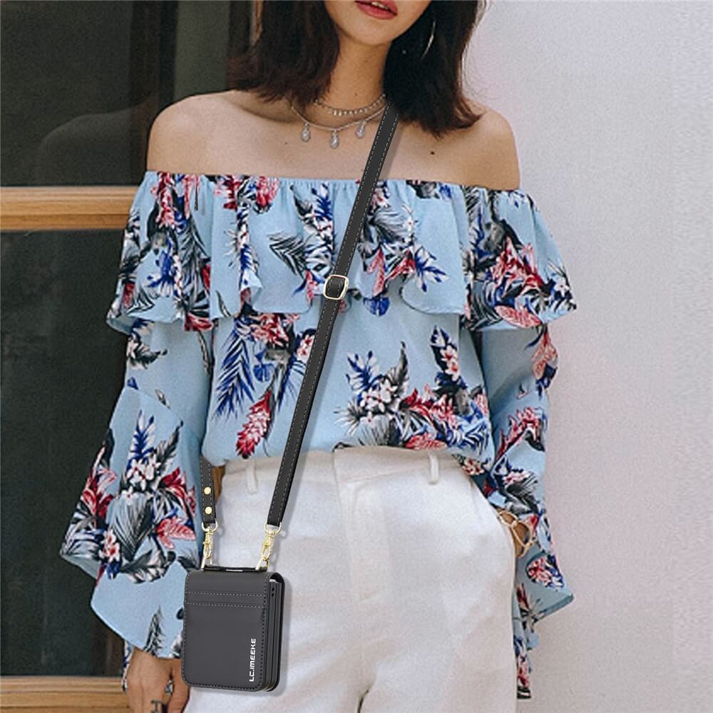 Eine Frau in einer schulterfreien geblümten Bluse und einer weißen Hose mit einer schwarzen Umhängetasche steht an einem Fenster und hält ihre LC.IMEEKE L1 Series Leder Etui Hülle für Galaxy Z Flip7 stilvoll in der Hand.