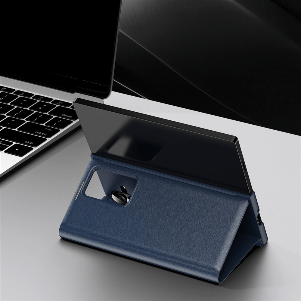 Ein Galaxy Z Fold7 in einer blauen Cover-Discount Smart Cover Window View steht aufrecht neben einem Laptop auf einem grauen Schreibtisch.