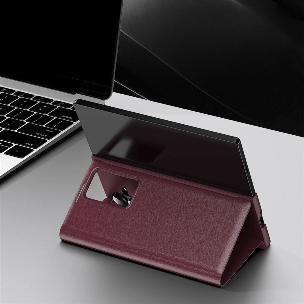 Ein Galaxy Z Fold7 in einem kastanienbraunen Smart Cover Window View von Cover-Discount steht aufrecht neben einem Laptop auf einem grauen Schreibtisch.