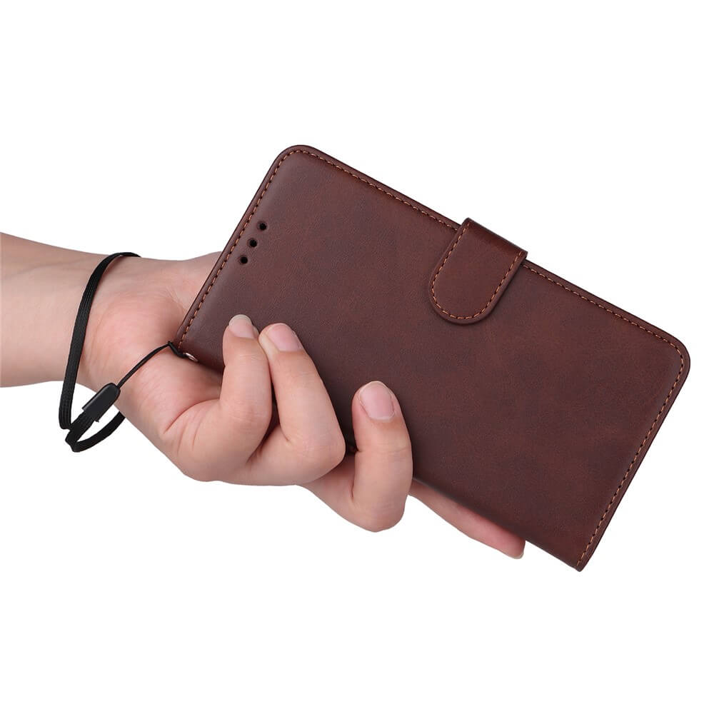 Hand hält braune Leder-Wallet-Hülle mit Magnetverschluss und schwarzem Handgelenkriemen vor weißem Hintergrund.