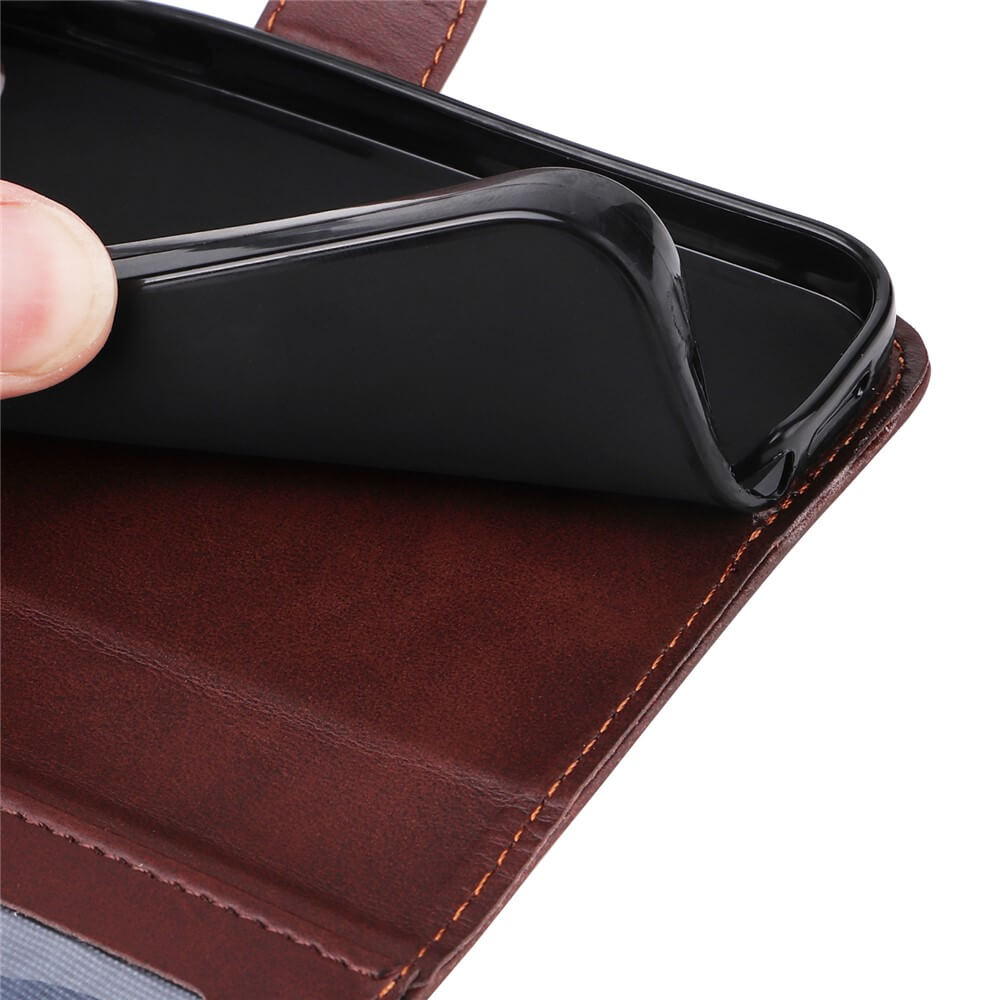 Daumen hebt schwarze Schutzhülle in brauner Leder-Wallet mit orangefarbener Naht und Sichtfenster an.