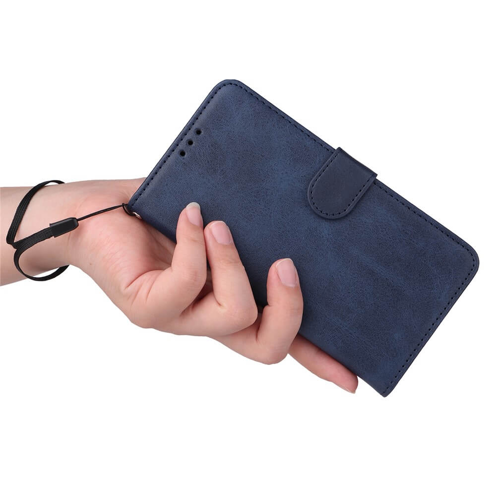 Eine linke Hand hält ein navyblaues, klappbares Handyetui mit Riemen und schwarzem Handgelenkband vor weißem Hintergrund.