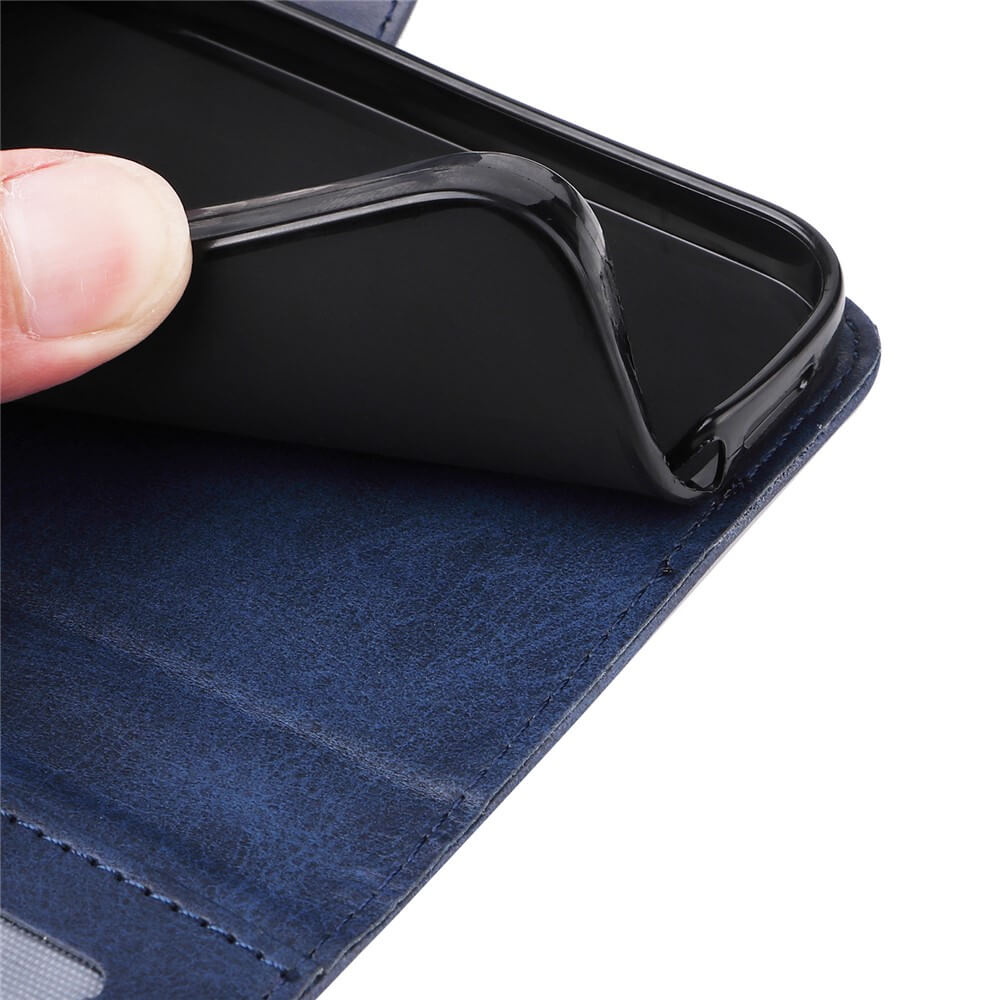 Nahaufnahme einer Hand, die eine flexible schwarze Handyhülle aus einer blauen, strukturierten Handyhülle mit sichtbaren Nähten zieht.